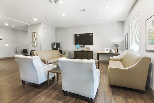 Community room with comfortable couches and armchairs surrounding a television